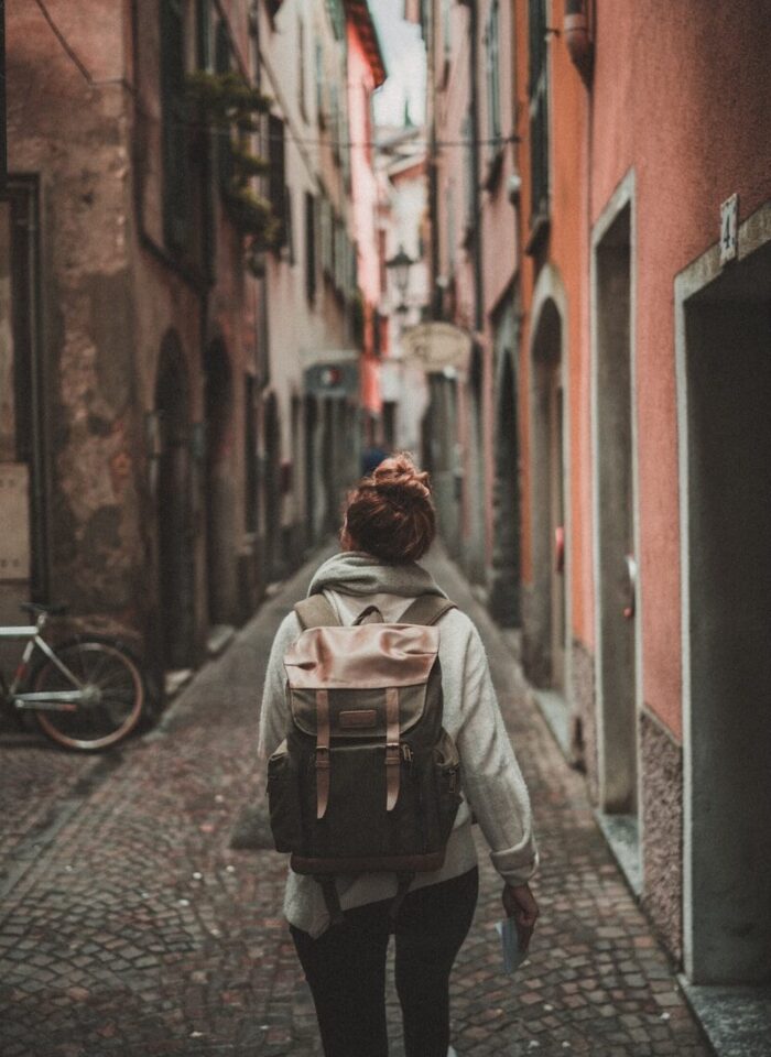 woman walking on street surrounded by buildings
